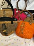 Kenyan sisal kiondo with a short leather handle. Beads and leather strips at the front.